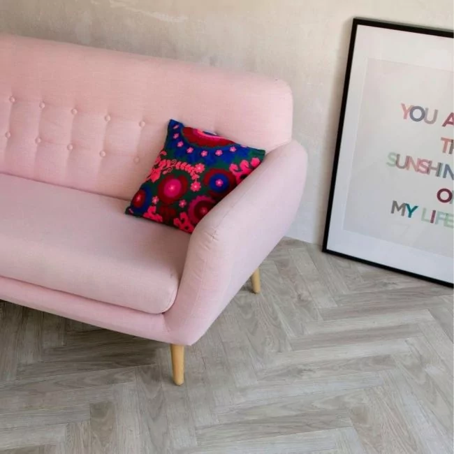 berry alloc java light grey parquet laminate flooring in living room with pink couch and black photo frame
