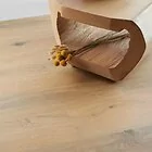 medium oak laminate flooring planks in 8mm thickness with 4v bevelled edges in hallway with flowers gyant natural